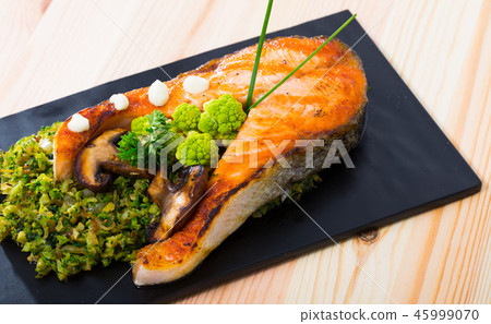 Salmon steak served with broccoli Salmon steak served with broccoli 45999070