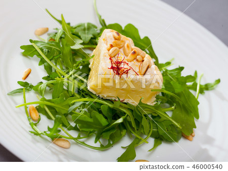Camembert with roasted pine nuts on arugula Camembert with roasted pine nuts on arugula 46000540