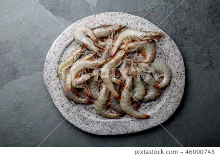 Raw whole fresh uncooked prawns shrimps on stone gray plate, stone background. Top view with copy Raw whole fresh uncooked prawns shrimps on stone gray plate, stone background. Top view with copy 46000748
