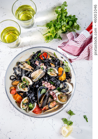 Homemade seafood Black pasta spaghetti with clams mussels octopus vongole in pan with white wine on 46001046
