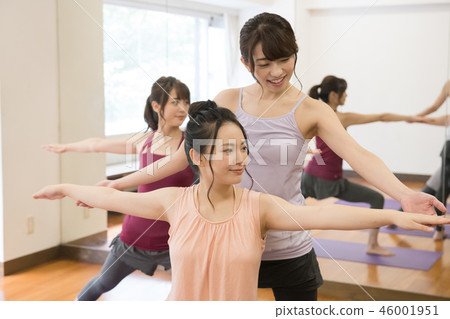 指導員與參加瑜伽課程的女性一起調整 46001951