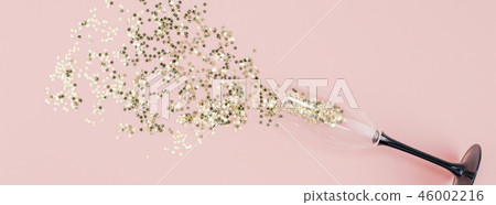 Champagne glass poured out golden stars confetti Champagne glass poured out golden stars confetti 46002216