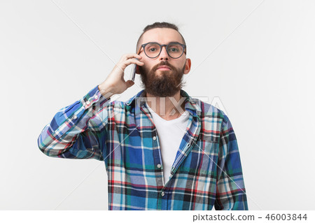 Technologies, fashion and people concept - Cool man with beard using telephone over white background Technologies, fashion and people concept - Cool man with beard using telephone over white background 46003844