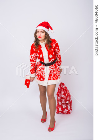 Holidays, Christmas and gifts concept - Beautiful woman in Santa costume with big and heavy bag of Holidays, Christmas and gifts concept - Beautiful woman in Santa costume with big and heavy bag of 46004060