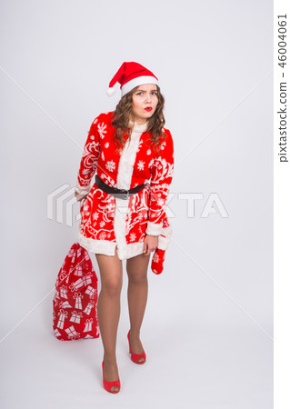 People, christmas and holidays concept - young woman in santa claus costume holding bag with gifts People, christmas and holidays concept - young woman in santa claus costume holding bag with gifts 46004061