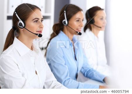 Call center. Group of operators at work. Focus at beautiful business woman in headset 46005794