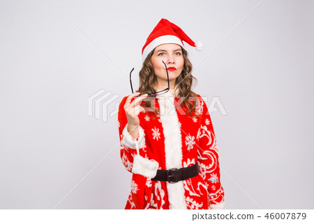 Christmas, holidays and people concept - young woman in santa suit took off glasses on white 46007879