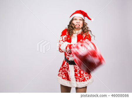 Christmas, emotions and people concept - angry woman in santa claus clothes holding presents on Christmas, emotions and people concept - angry woman in santa claus clothes holding presents on 46008086