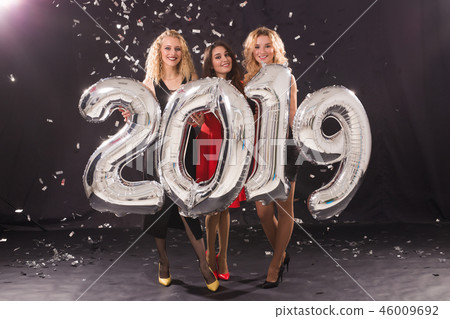 Party, people and new year holidays concept - cheerful young women celebrating new years eve 2019 Party, people and new year holidays concept - cheerful young women celebrating new years eve 2019 46009692