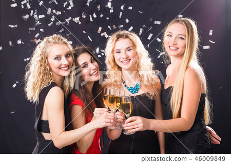 Party, holidays, celebration and new year eve concept - Cheerful young woman clinking glasses of 46009849