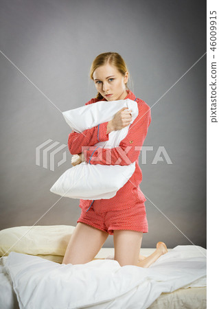 Sad depressed girl in bed gripping pillow 46009915