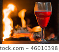 Glass of red wine near fireplace  46010398