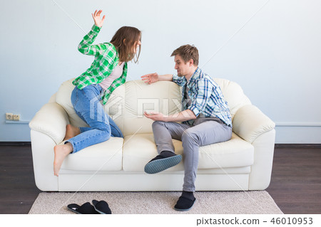 Bad relationship concept. Young couple sitting on couch at home having quarrel, offended wife and Bad relationship concept. Young couple sitting on couch at home having quarrel, offended wife and 46010953