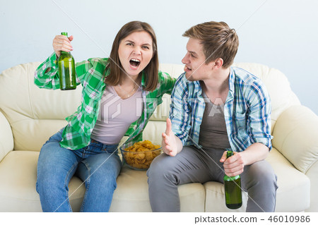 Friends watch sports on TV together, drink beer. Fans cheer for their team. Friends watch sports on TV together, drink beer. Fans cheer for their team. 46010986