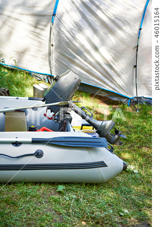 Fishing boat with motor on background of tent Fishing boat with motor on background of tent 46015164