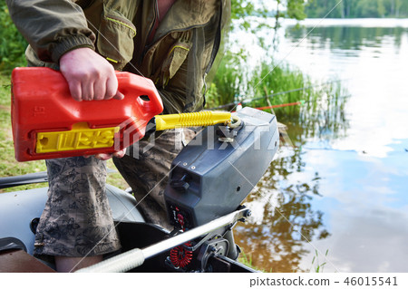 Fisherman pours gasoline in engine of fishing boat Fisherman pours gasoline in engine of fishing boat 46015541