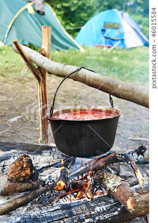 Bowler with soup on campfire and tourist tents Bowler with soup on campfire and tourist tents 46015584