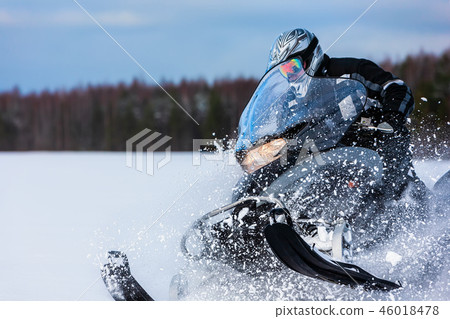 In powder snowdrift snowmobile rider driving fast. 46018478