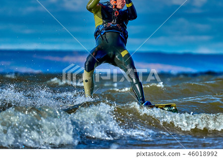 A male kiter slides on the surface of the water A male kiter slides on the surface of the water 46018992