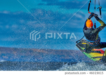 A male kiter jumps over a large lake. Close-up. A male kiter jumps over a large lake. Close-up. 46019015