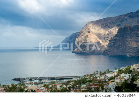 Los Gigantes rocks in sun beams. Dramatic sky and calm ocean. Los Gigantes rocks in sun beams. Dramatic sky and calm ocean. 46019844