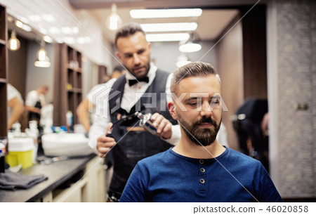 Hipster man client visiting haidresser and hairstylist in barber shop. Hipster man client visiting haidresser and hairstylist in barber shop. 46020858
