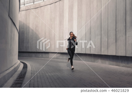 Young athlete is running near the stadium. Young athlete is running near the stadium. 46021829