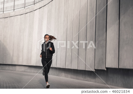 Young athlete is running near the stadium. Young athlete is running near the stadium. 46021834