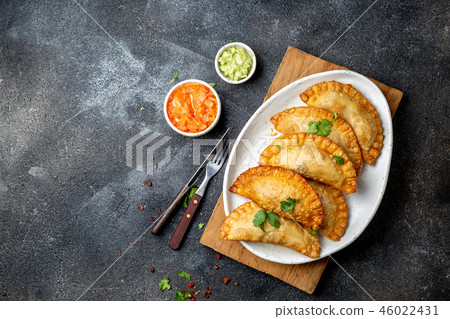 Latin American fried empanadas with tomato and avocado sauces. Top view 46022431