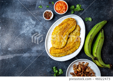 COLOMBIAN CARIBBEAN CENTRAL AMERICAN FOOD. Patacon or toston, fried and flattened whole green 46022473