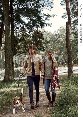 Young couple are walking with dog in forest 46022970