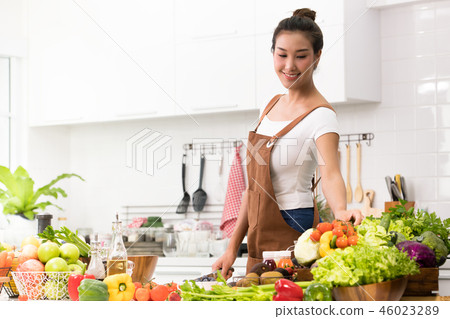 Asian woman in a kitchen preparing healthy meal Asian woman in a kitchen preparing healthy meal 46023289