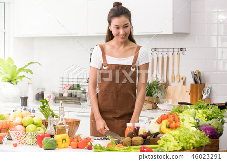Asian woman in a kitchen preparing healthy meal Asian woman in a kitchen preparing healthy meal 46023291
