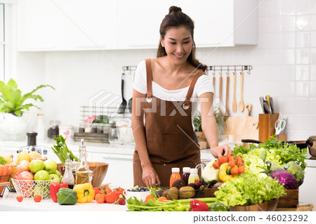 Asian woman in a kitchen preparing healthy meal Asian woman in a kitchen preparing healthy meal 46023292