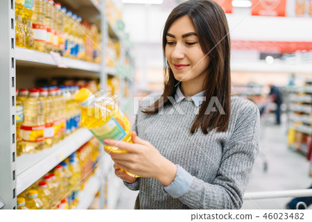 Woman choosing sunflower oil in a supermarket 46023482