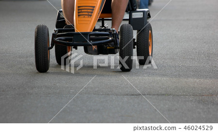 Boy rides a velomobile outdoors. 46024529