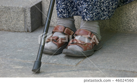 Old woman sitting with walking stick. Old woman sitting with walking stick. 46024560