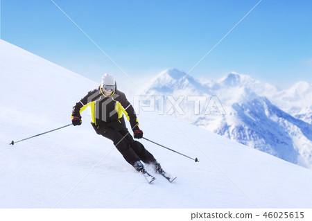 Alpine skier on piste running downhill Alpine skier on piste running downhill 46025615