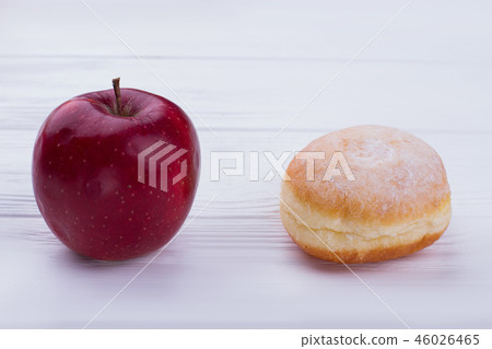 Tasty donut and fresh red apple. Tasty donut and fresh red apple. 46026465
