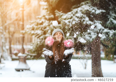 The girl throws snow up in the city. The girl throws snow up in the city. 46027259