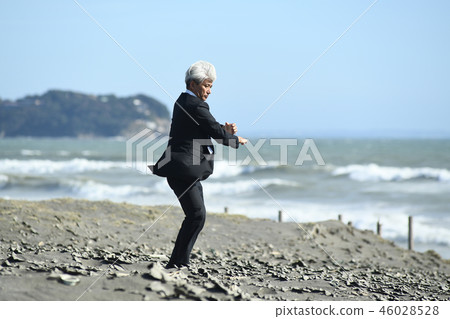 Romance gray businessman hitting karate type on sandy beach 46028528