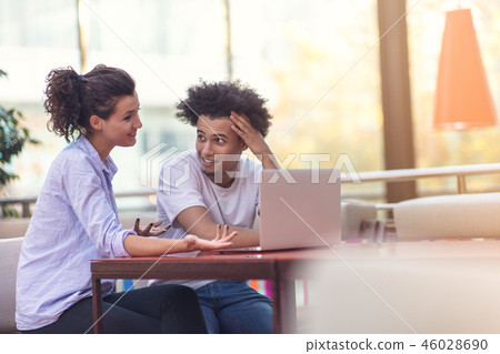 Interracial couple using tablet computer in coffee shop Interracial couple using tablet computer in coffee shop 46028690