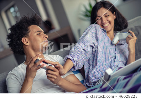 Image of young loving couple in kitchen at home indoors. Eating pizza and playing games with console Image of young loving couple in kitchen at home indoors. Eating pizza and playing games with console 46029225