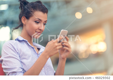 Young woman busy with calling, chatting on the cell phone side view portrait. 46029302