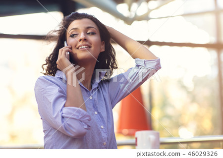 Portrait Of Young Girl Talking On phone while drinking coffee 46029326