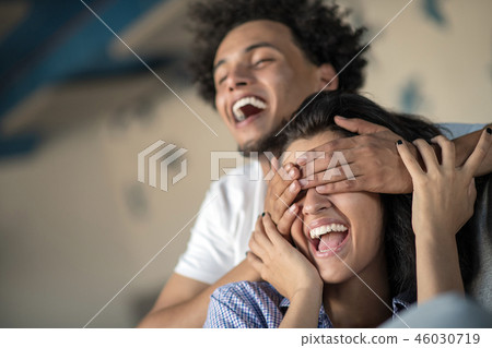 Young black couple relaxing on couch and smiling at camera Young black couple relaxing on couch and smiling at camera 46030719