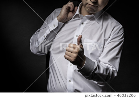 A man with a suit jacket on his shoulder 46032206