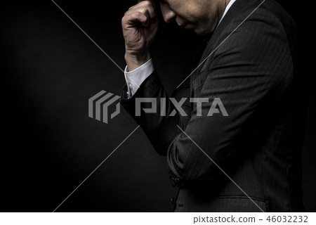 A man suffering from holding his head 46032232