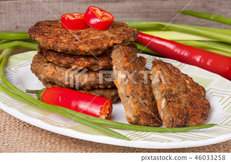 liver pancakes or cutlets with chili pepper and green onions on a wooden background liver pancakes or cutlets with chili pepper and green onions on a wooden background 46033258