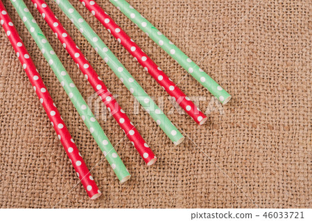 Colorful drinking striped straws on the background of burlap Colorful drinking striped straws on the background of burlap 46033721